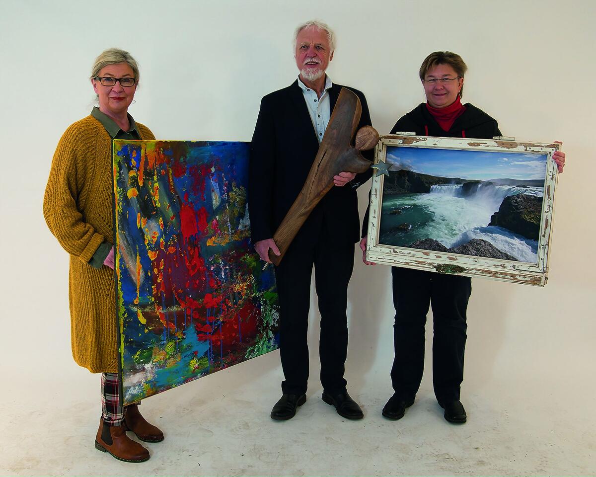 Bild vergrößern: Die Künstler*innen B. Hagen, D. Wrede und S. Berndt halten ein Bild, eine Skulptur und ein gerahmtes Foto